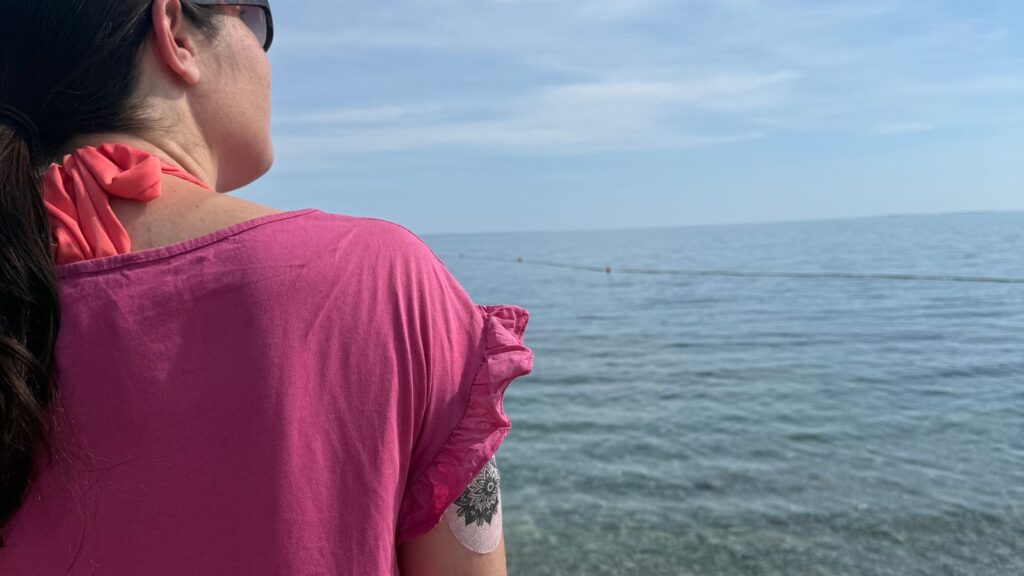 Sladkorna bolezen in poletje – oseba s senzorjem za glukozo na plaži
